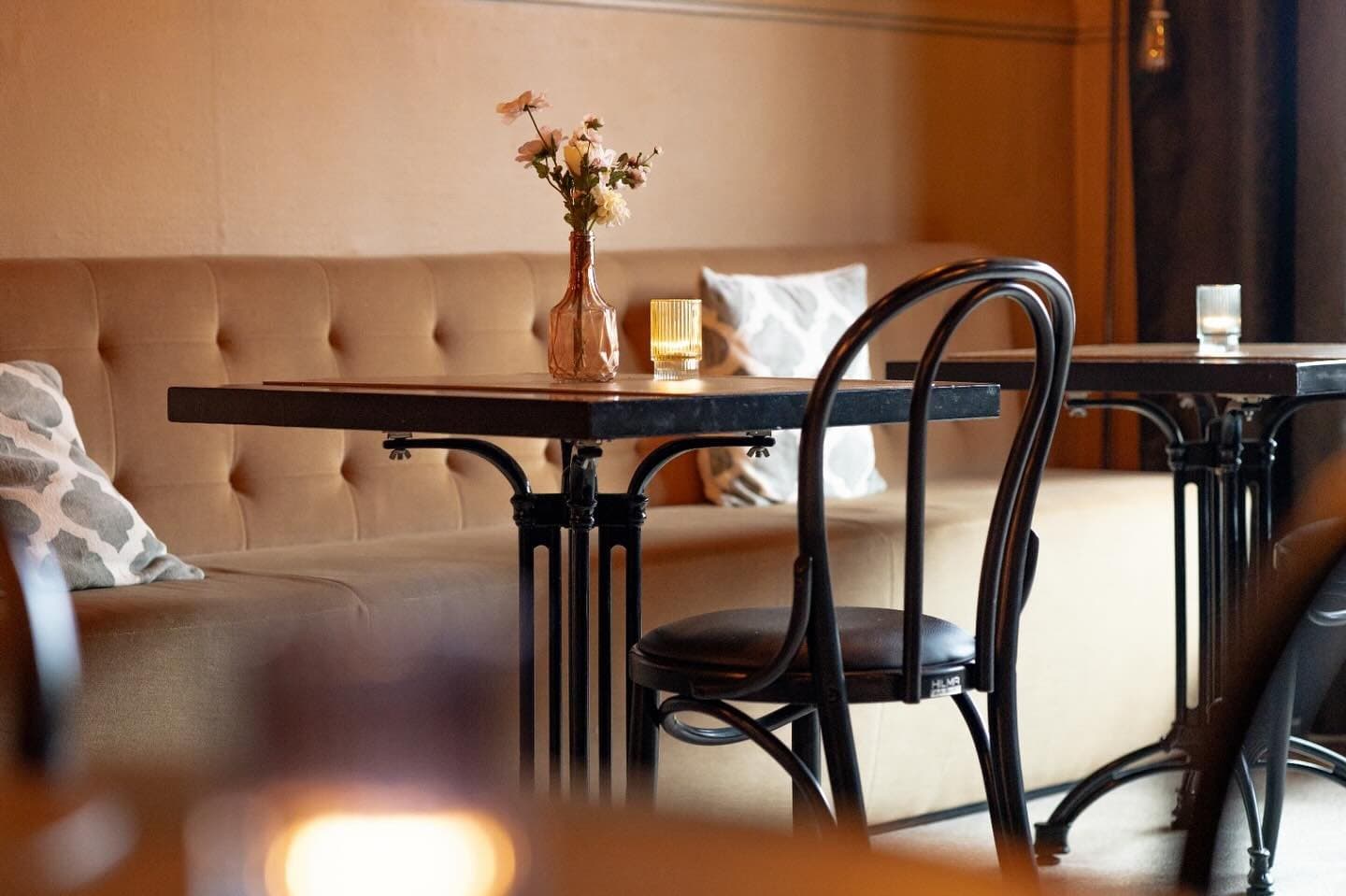 Een tafeltje met bloemen en een kaarsje in de tearoom van Tartelier
